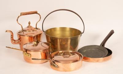A collection of copper pans, kettles