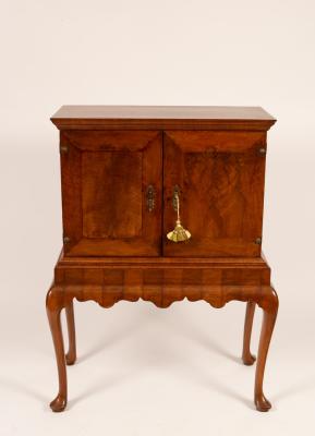 A walnut cabinet on stand fitted