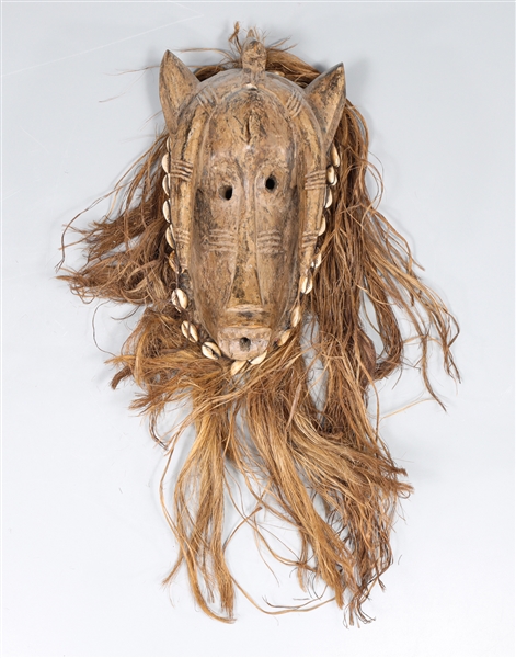 Carved tribal mask with straw mane