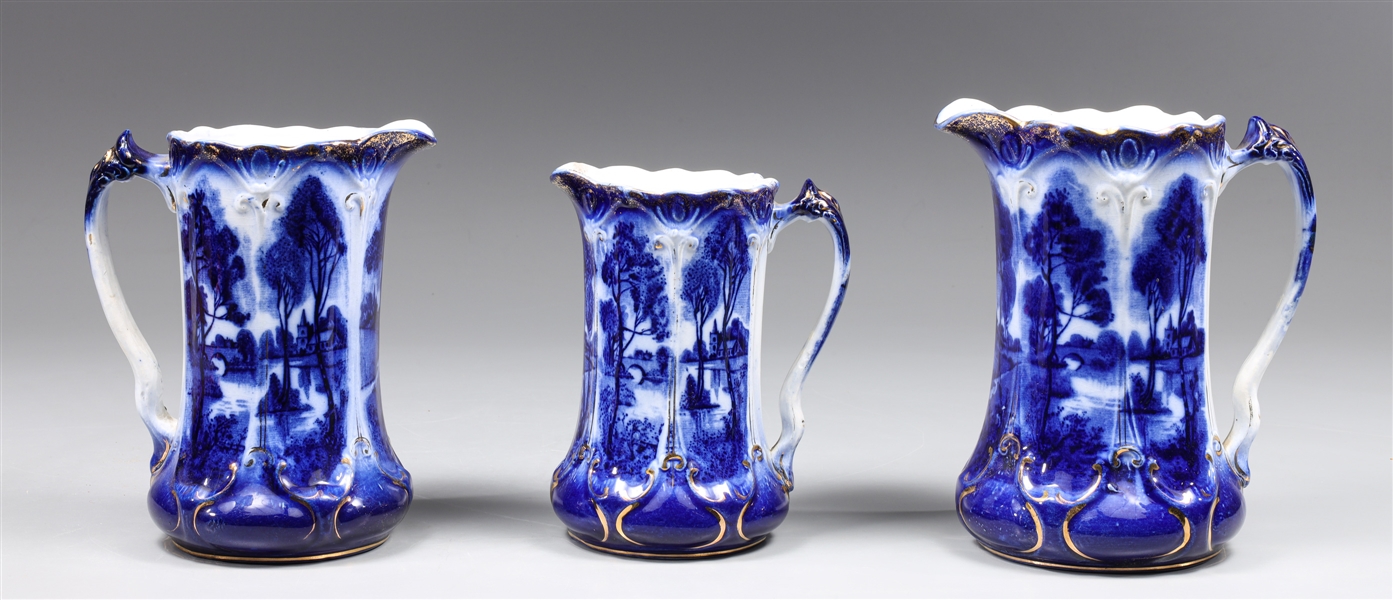 Group of thee antique flow blue pitchers