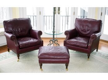 A pair of maroon leather club chairs 305879