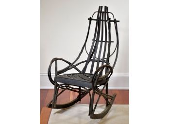 An antique black painted, bent