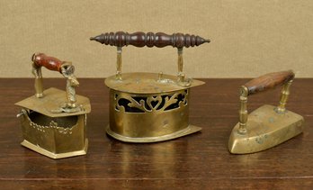 Three antique brass irons, one