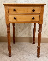 An antique two drawer stand with birdseye