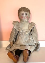An antique doll with a painted leather