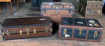 A grouping of three travel/steamer trunks.