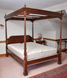 A vintage mahogany canopy bed frame