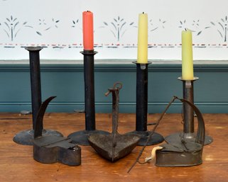 Four antique hog scraper candlesticks