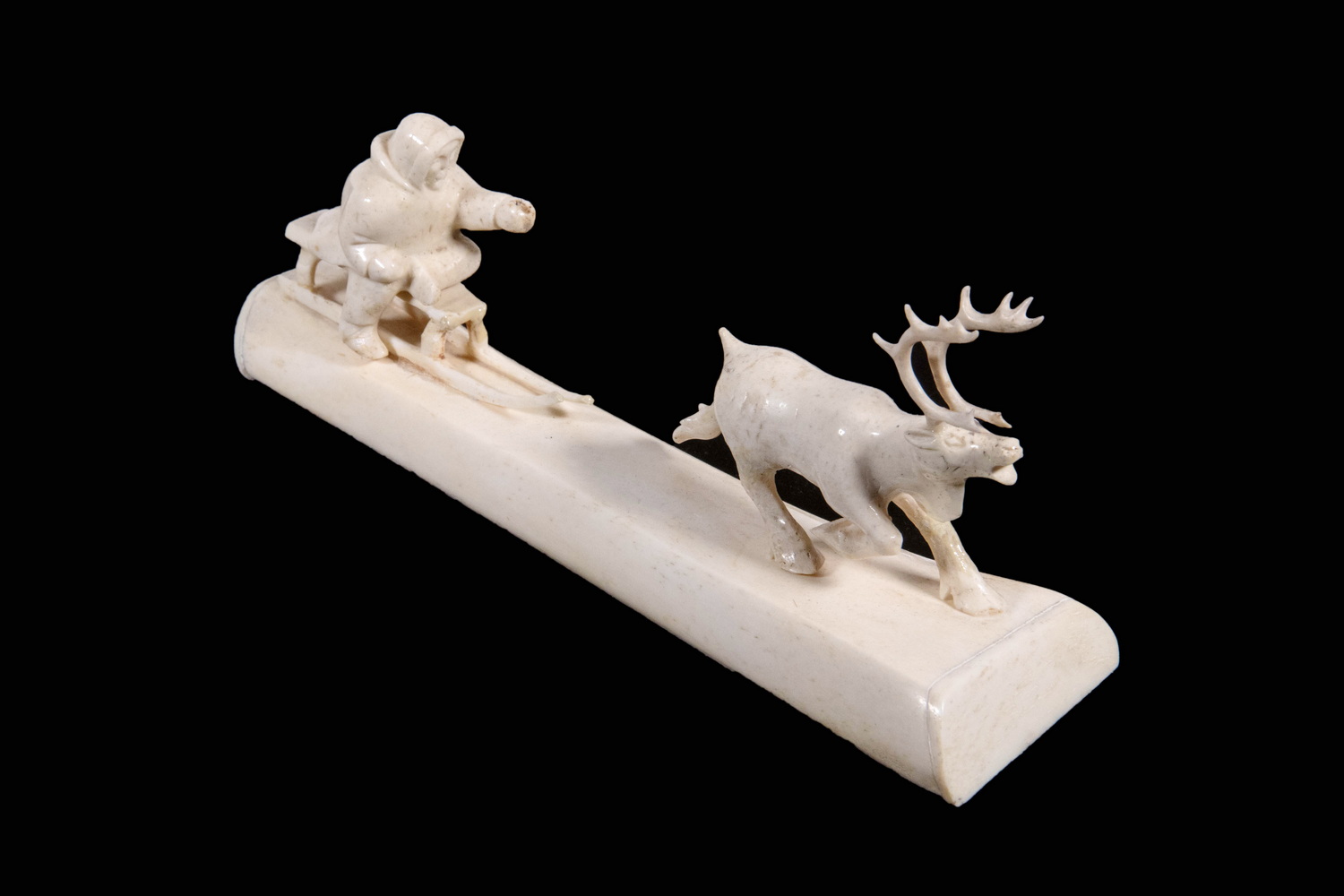 INUIT CARVED BONE MAN ON SLED WITH