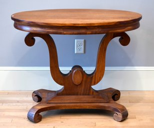 An antique mahogany table with an oval