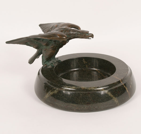 Bronze eagle perched on marble bowl.