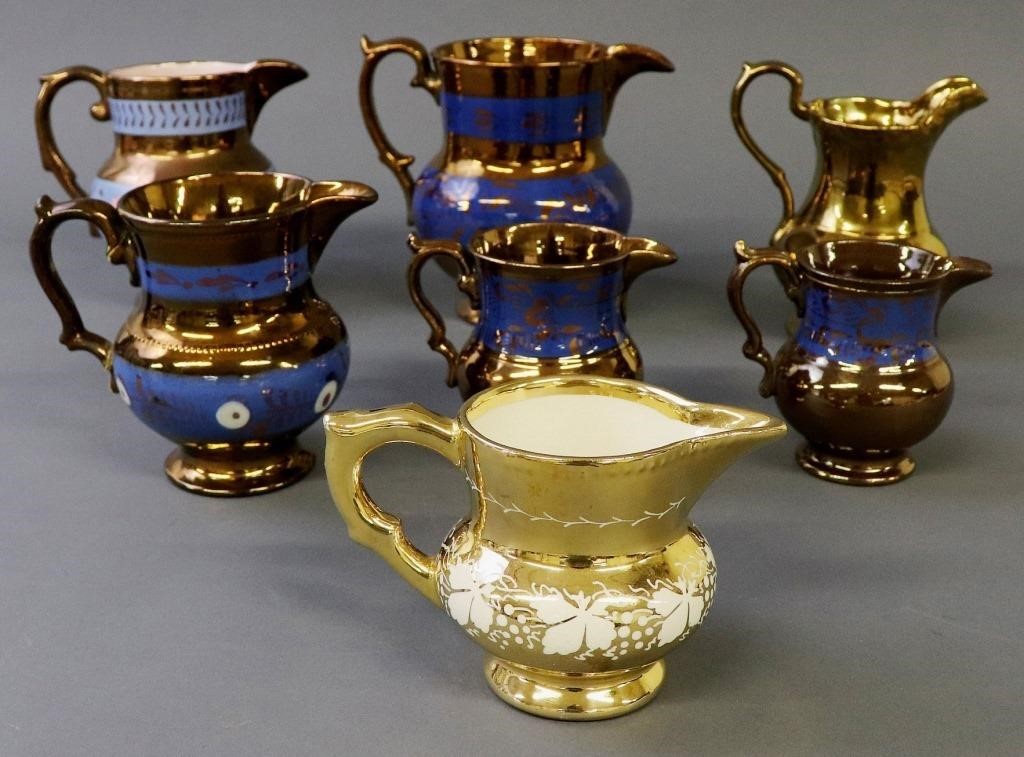 Seven copper lustre pitchers, tallest
