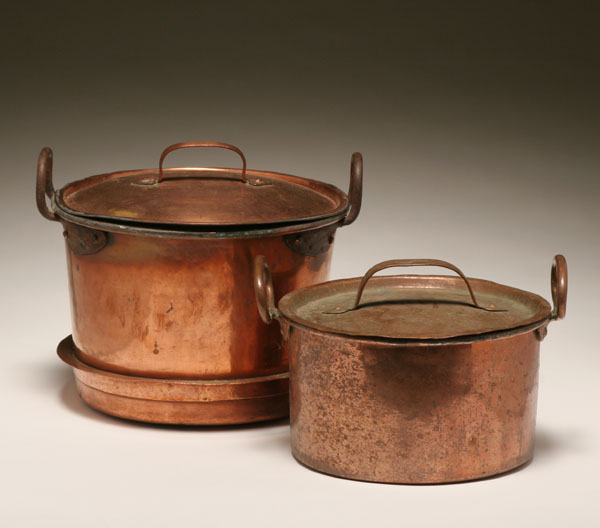 Two early copper pots with lids; strap