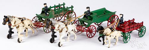 THREE KENTON CAST IRON HORSE DRAWN WAGONSThree