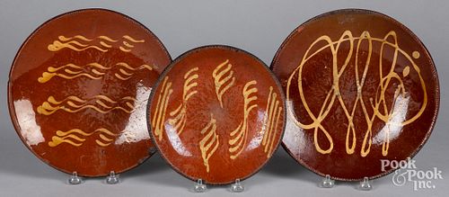 THREE SLIP DECORATED REDWARE PLATES,