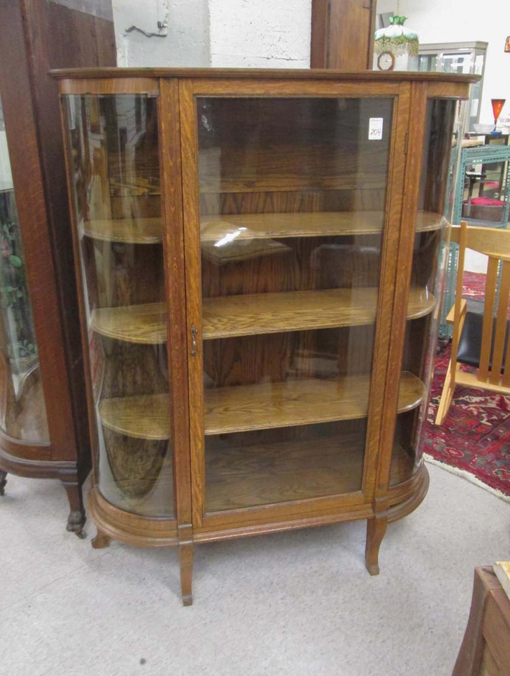 AN OAK AND CURVED GLASS CHINA CABINET,