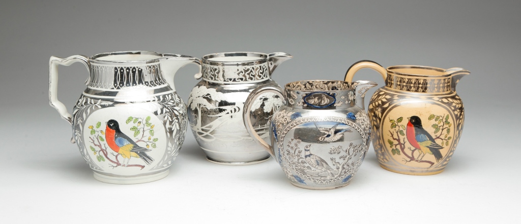 FOUR ENGLISH SILVER RESIST PITCHERS.