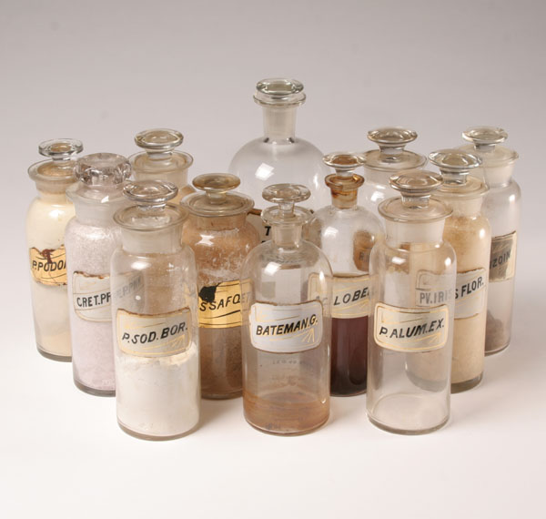 Twelve stoppered pharmacy bottles