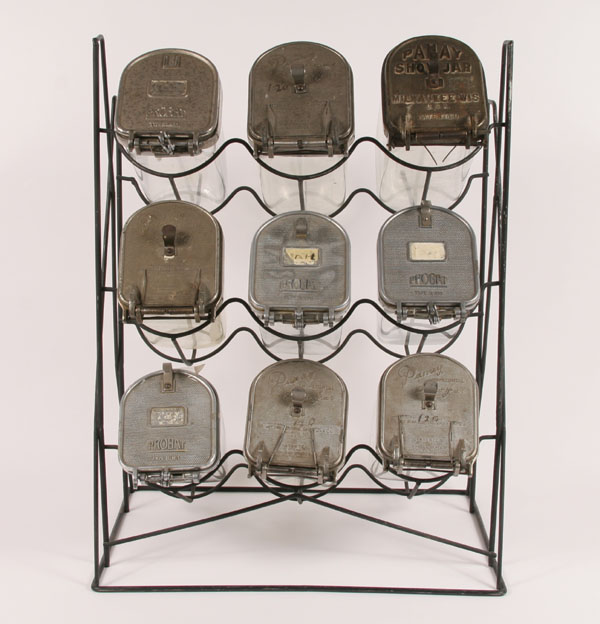 Nine large glass seed jars on iron rack: