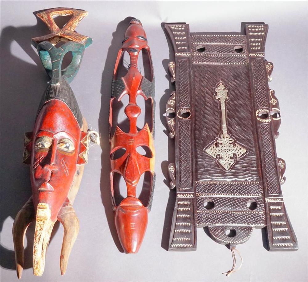 TWO PAINTED WOOD MASKS AND A PLAQUETwo