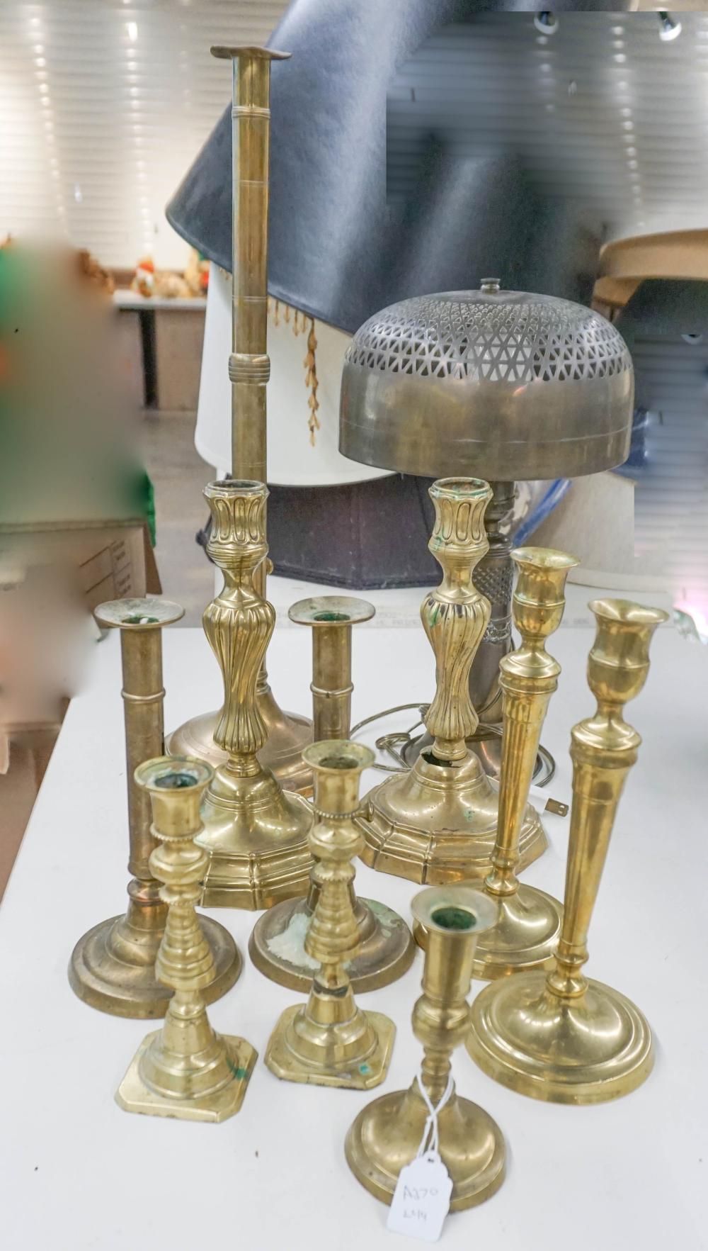 TEN BRASS CANDLESTICKS AND A LAMP,