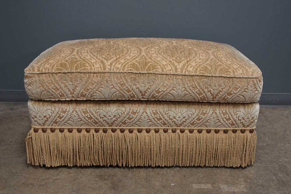 BEIGE UPHOLSTERED OTTOMANwith fringed 335d50