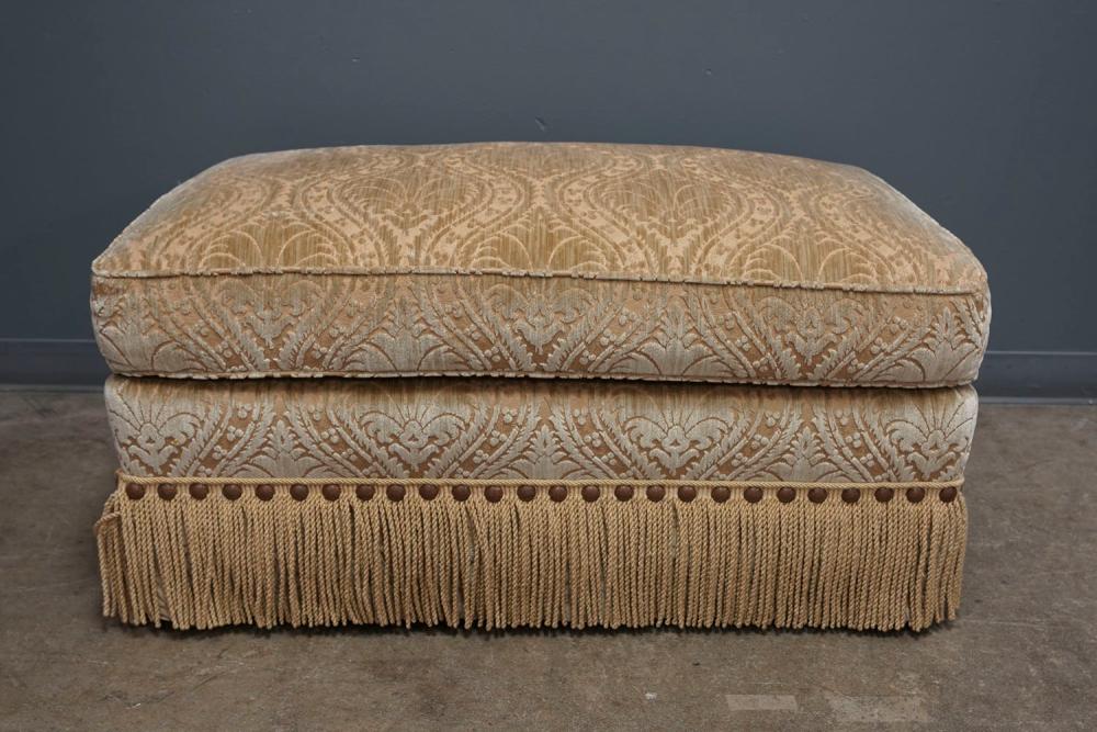 BEIGE UPHOLSTERED OTTOMANwith fringed