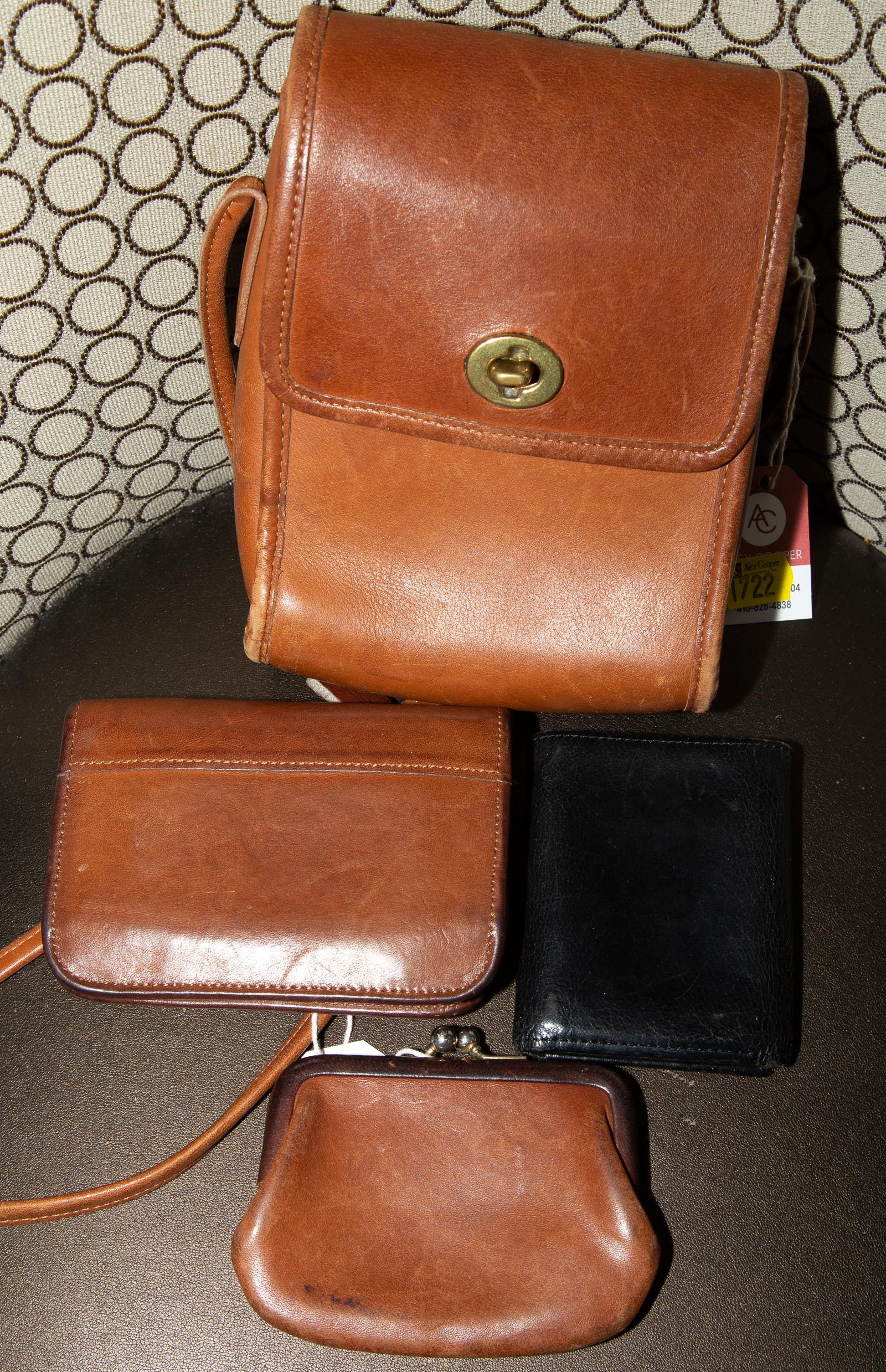 A BROWN LEATHER BAG & THREE LEATHER
