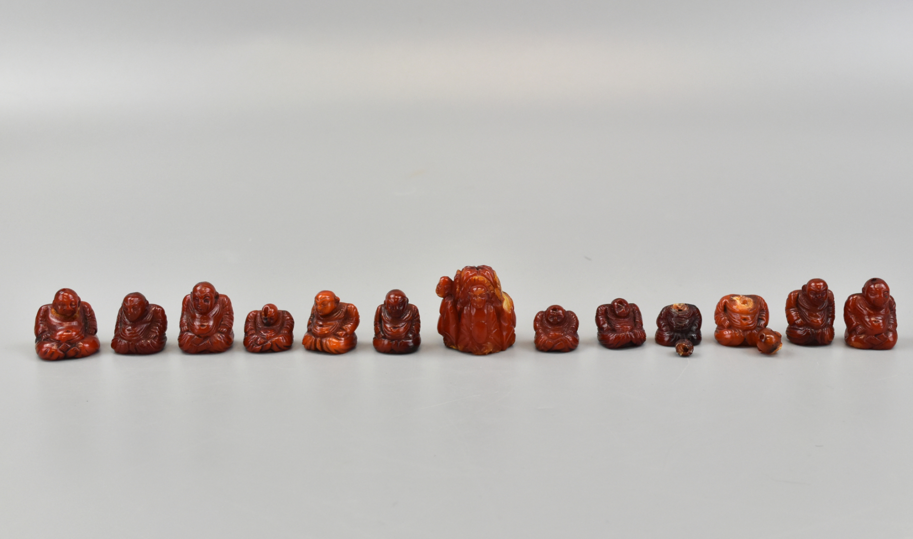 GROUP OF 13 MINIATURE BEESWAX BUDDHA