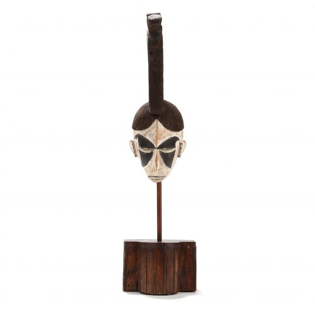 A LARGE AFRICAN IGBO MASK ON STAND