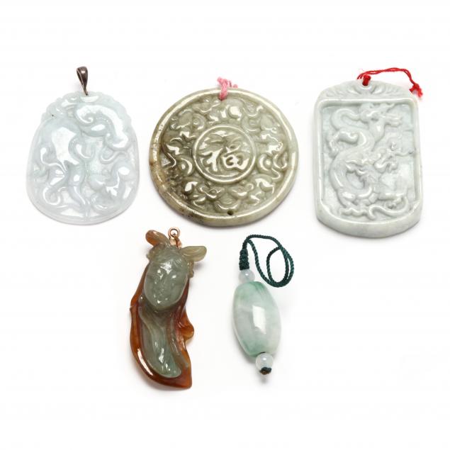 FIVE CARVED JADE PENDANTS To include: