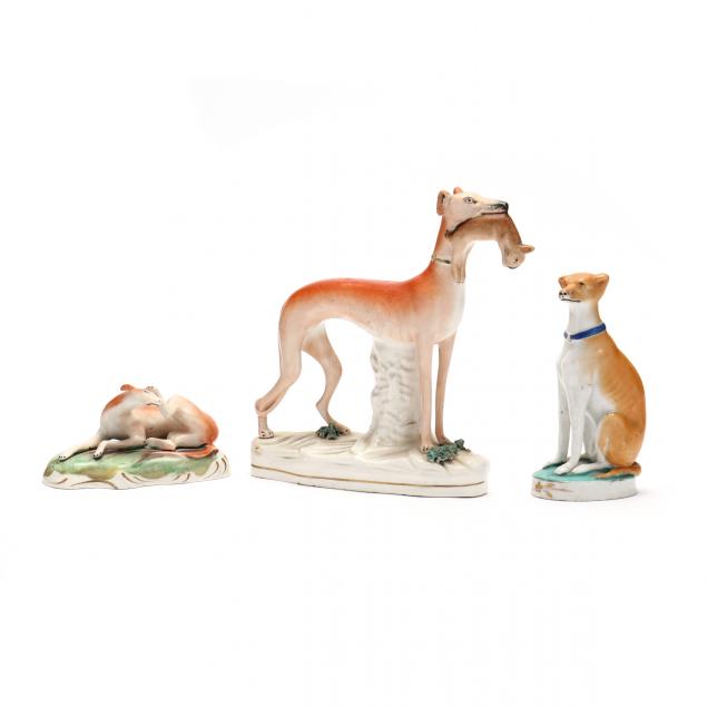 THREE STAFFORDSHIRE WHIPPETS A seated