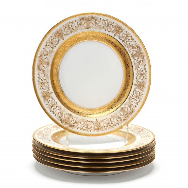 A SET OF SIX GILT ENCRUSTED DINNER PLATES