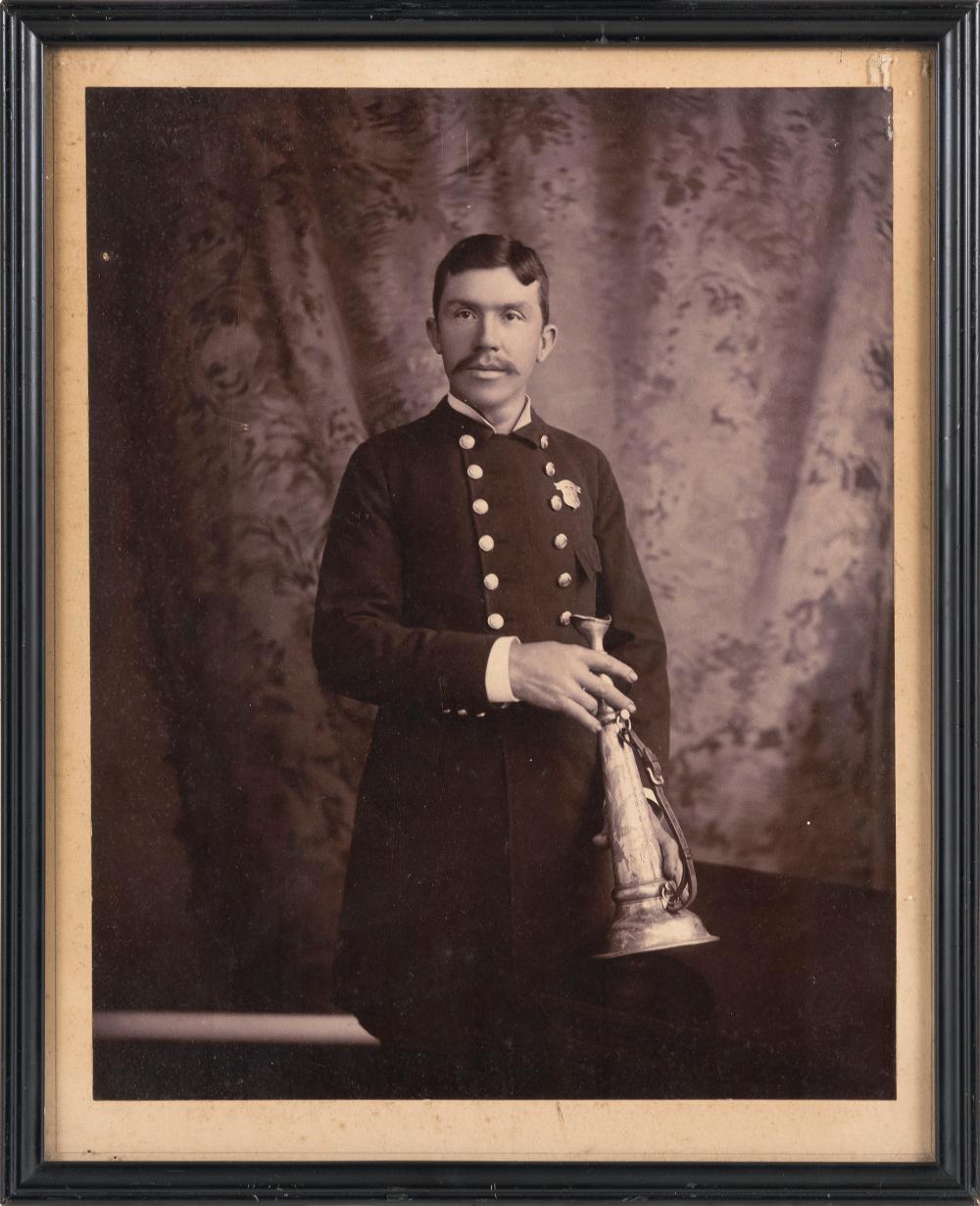 PHOTOGRAPH OF A FIREMAN HOLDING A FIRE