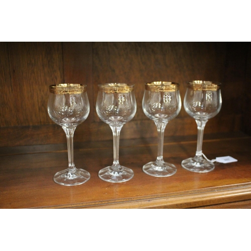 Four wine glasses with gold rims,