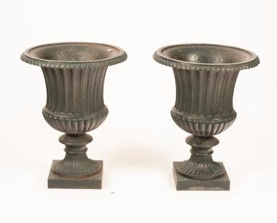 A pair of cast iron urns, green