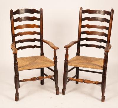 A pair of ash framed ladder back chairs