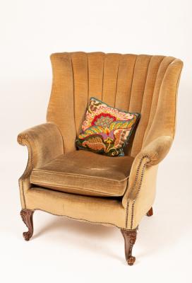 A beige upholstered wingback armchair