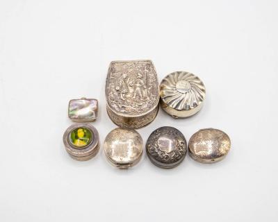Seven silver pill boxes, including