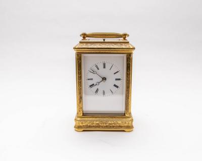 A brass carriage clock, engraved