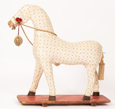 A fabric covered toy horse on a stand,