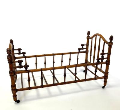 A dolls bed in faux bamboo, 64cm long