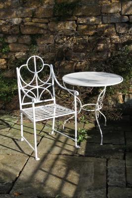 An iron garden armchair and table,