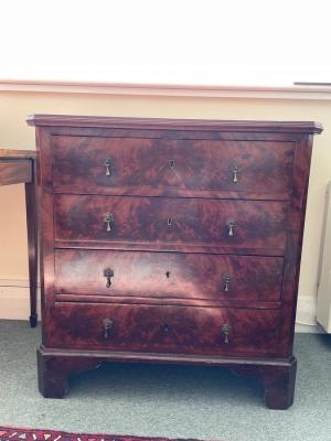 A mahogany veneered chest of four drawers