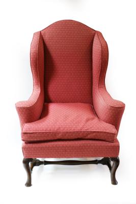 An upholstered wing back armchair, fitted