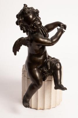 A bronze figure of a seated cherub,