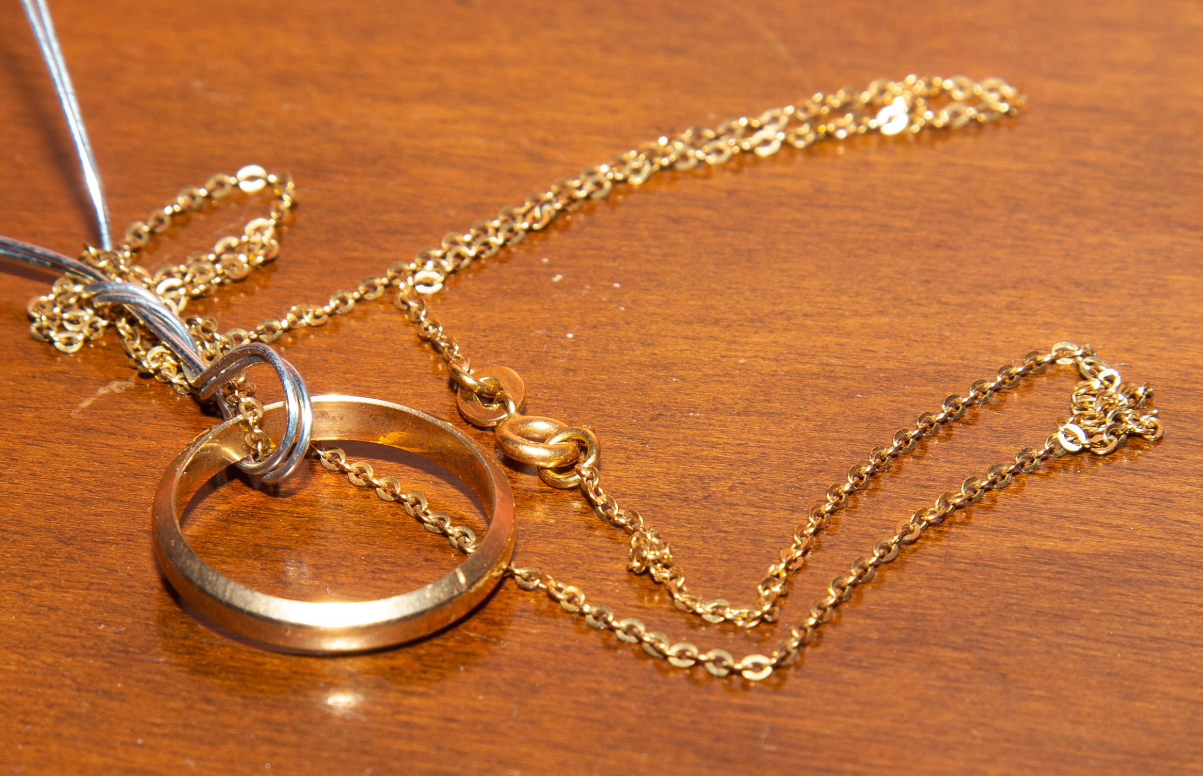 A 14K WEDDING BAND ON 18K CHAIN *located