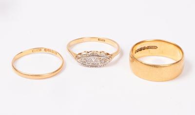 A 22ct gold wedding band, another
