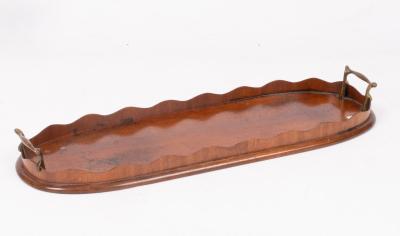 An oval mahogany tray with serrated