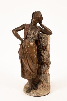 A bronzed metal figure of a maiden,